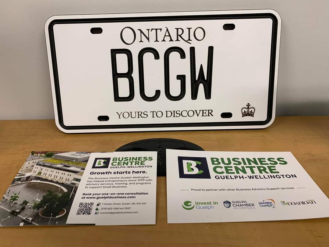 Image of a license plate with BCGW on it, and Business Centre postcards resting in front